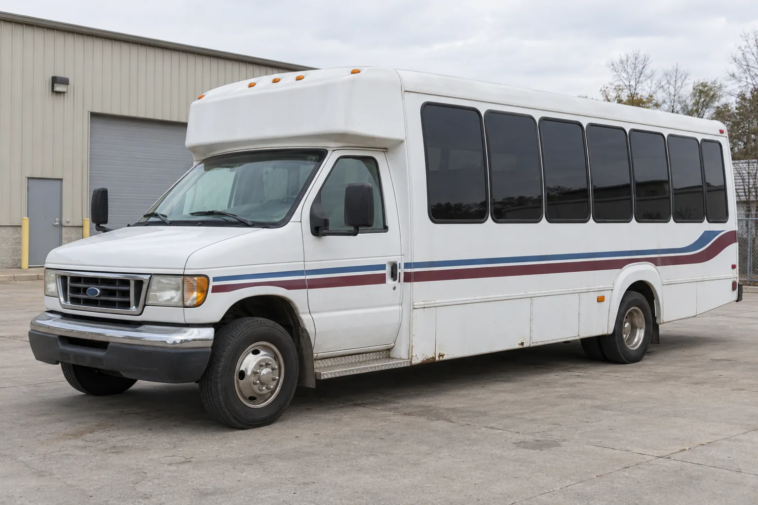 Original fictional concept of an older white shuttle bus with faded stripes before a proposed rebrand